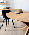 Ethnicraft Round Circle Dining Table made of natural oak with black chair in minimalist room