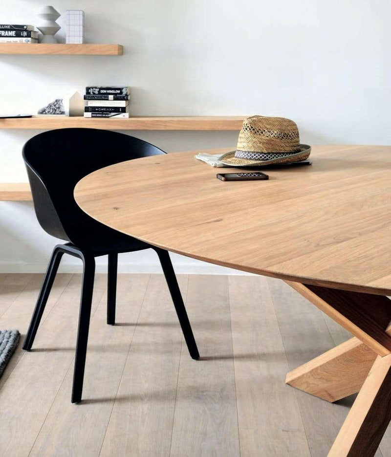 Ethnicraft Round Circle Dining Table made of natural oak with black chair in minimalist room