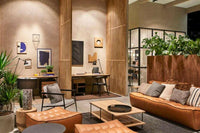 Ethnicraft Sofa N701 3-seater in old saddle aniline leather in modern living room setting with wooden and plant accents