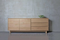 Ethnicraft Wave Sideboard large natural oak with 2 doors and 3 drawers against a grey wall