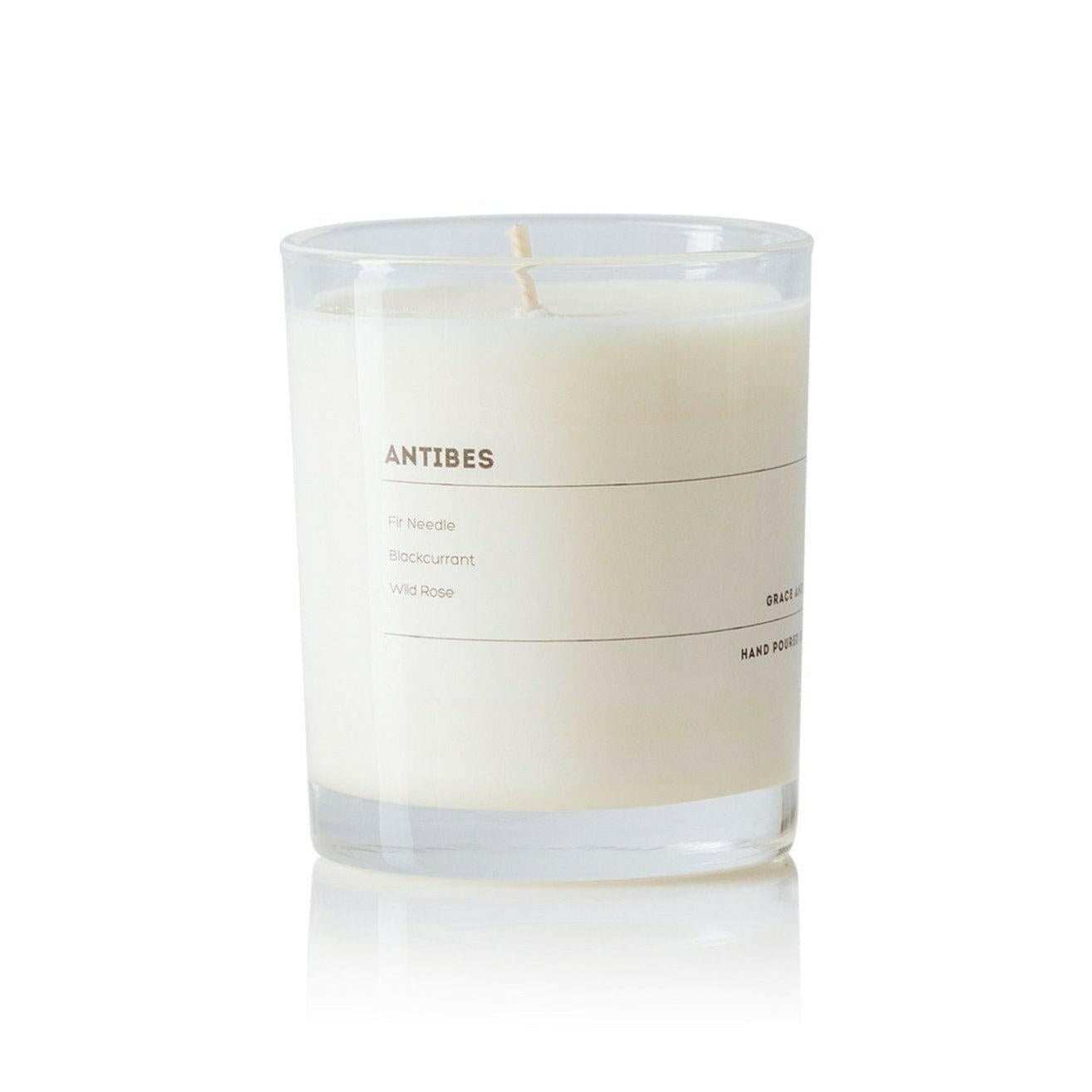 Grace and James Antibes scented candle with fir needle, blackcurrant, and wild rose fragrance in clear glass jar
