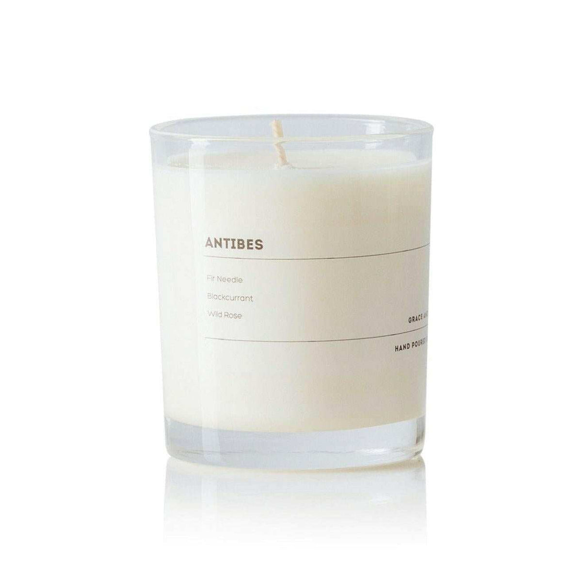 Grace and James Antibes scented candle with fir needle, blackcurrant, and wild rose fragrance in clear glass jar