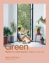 Book cover of Green by Jason Chongue showing a person sitting indoors surrounded by potted plants near a large open window with a green wall outside.