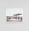 Minimalist framed print of a deserted highway gas station titled Middle Of Nowhere 'Highway' in a white frame behind glass