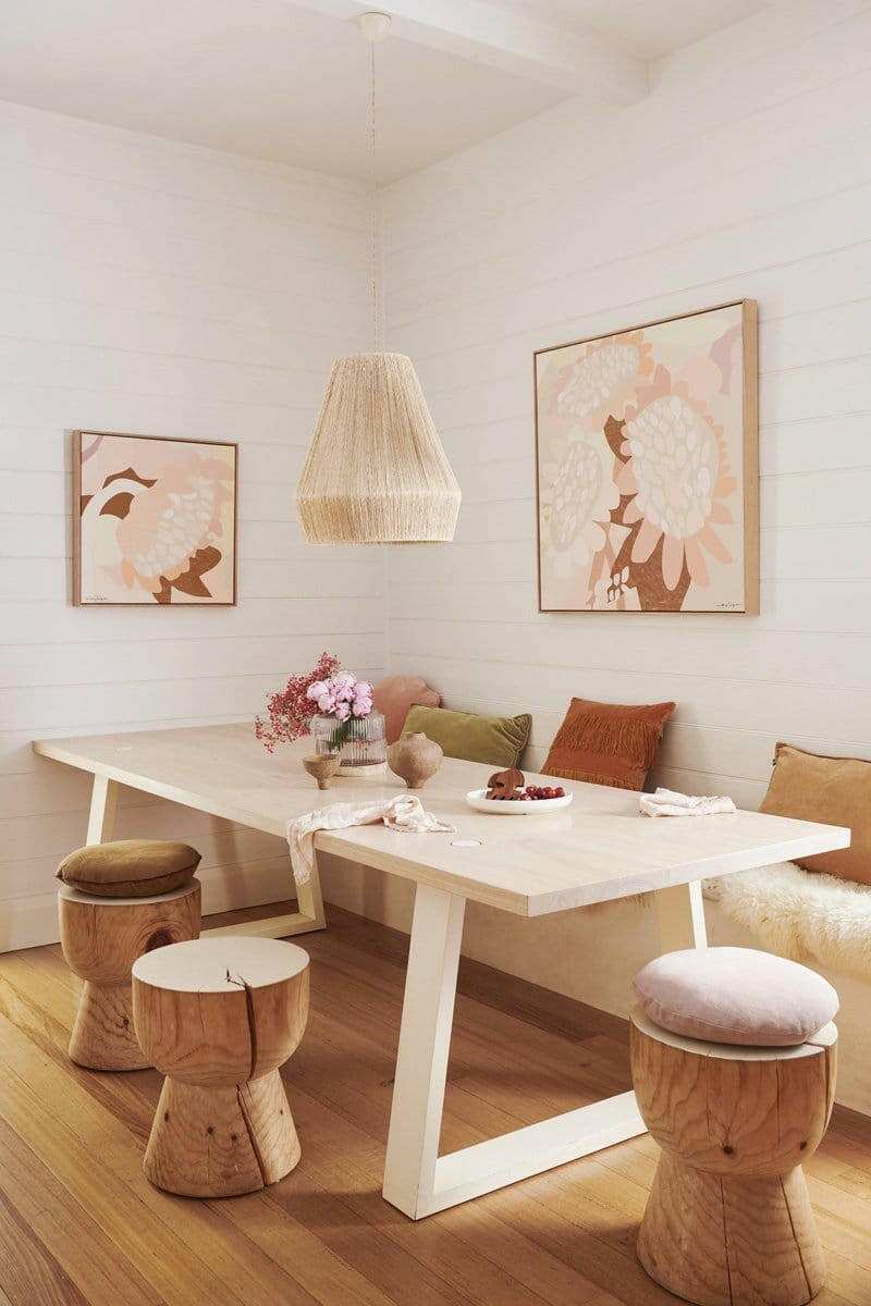 Kimmy Hogan Limited Edition fine art canvas print titled Dusk featuring soft floral illustration in neutral tones displayed in a modern dining room with wooden stools and a pendant light.