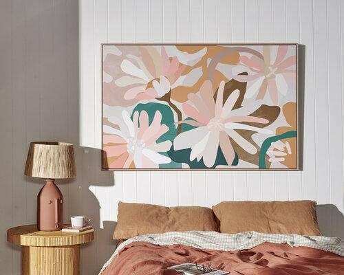 Kimmy Hogan Limited Edition Flowerbed III fine art canvas print with pastel floral design in floating oak frame above bed
