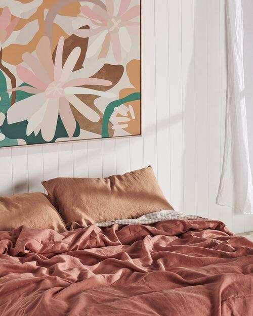 Kimmy Hogan Limited Edition Flowerbed III vibrant floral canvas print above bed with brown bedding in modern bedroom