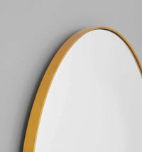 Middle of Nowhere Bjorn Arch floor mirror with brass frame and vintage gold leaf finish against gray wall