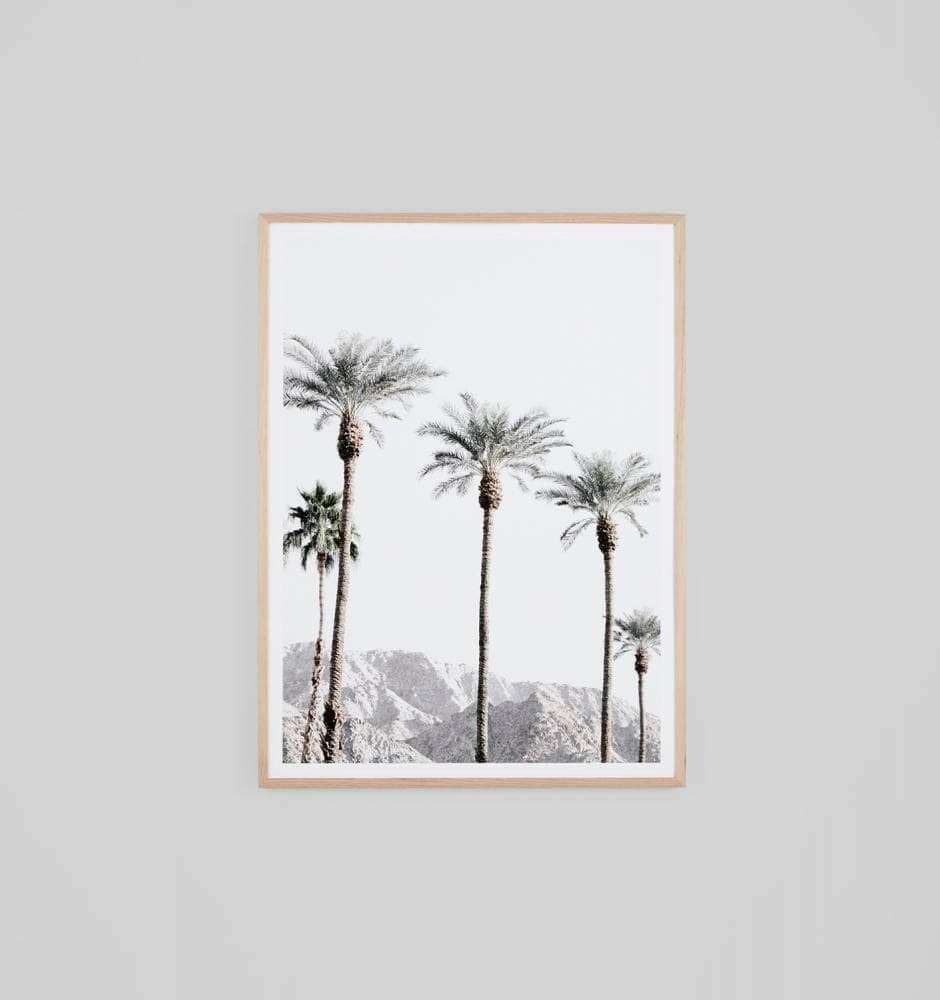 Middle of Nowhere California Vista Print featuring tall palm trees with mountains in the background, framed in oak.