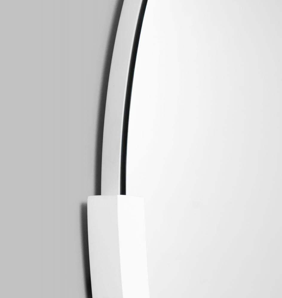 Close-up of Middle of Nowhere Dawn round bright white mirror with minimalist frame on gray wall