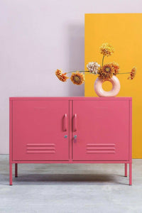 Pink Mustard Made Locker The Lowdown Berry storage cabinet with handles and vents, styled with a modern flower vase on top against a colorful background