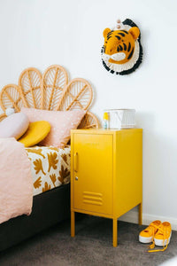 Yellow Mustard Made Locker with handle and lock next to a bed in a cozy bedroom setting