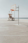 Newport Hoops Print featuring a basketball hoop on a beachside court with a lifeguard tower in the background