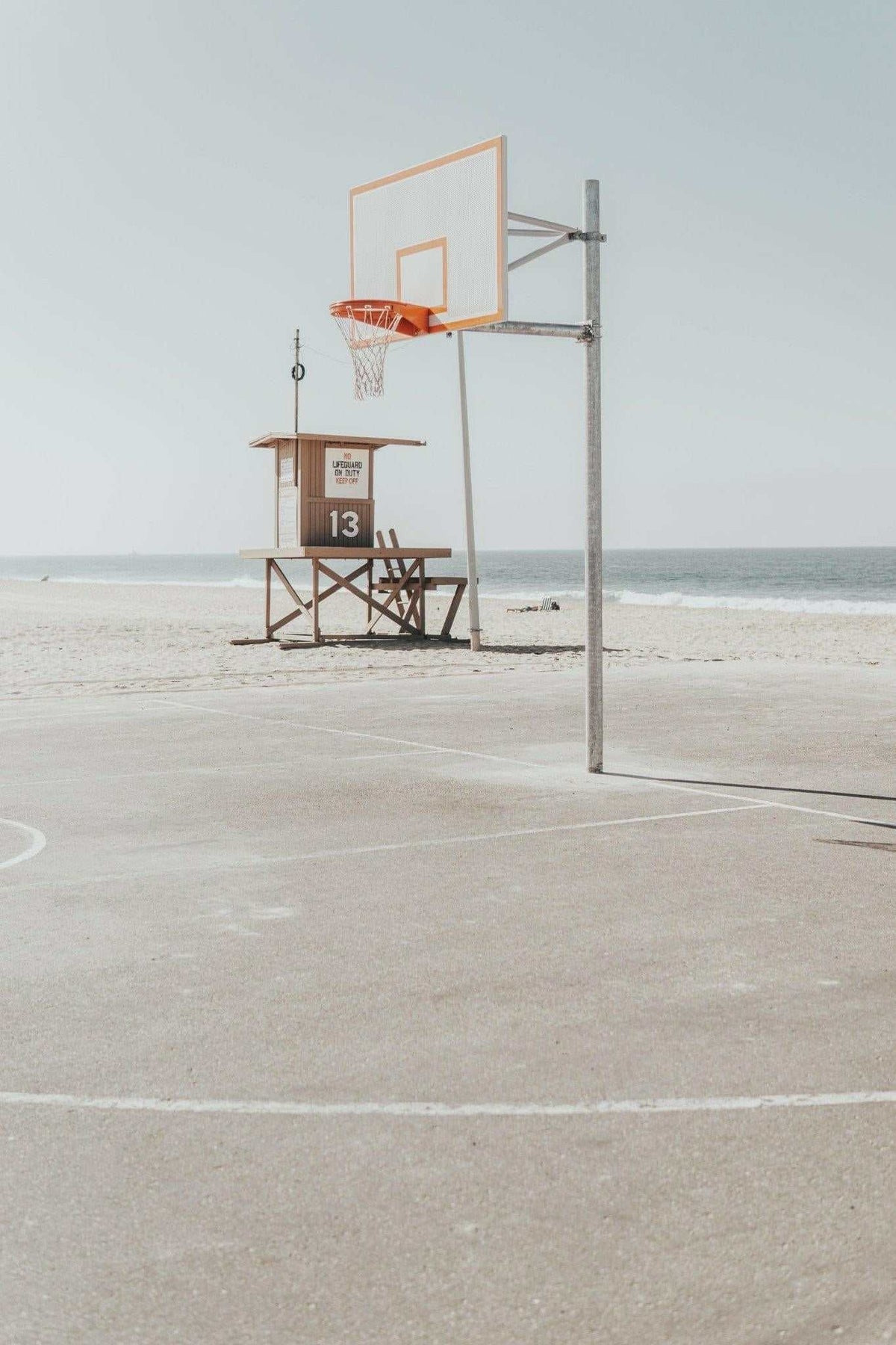 Newport Hoops Print featuring a basketball hoop on a beachside court with a lifeguard tower in the background