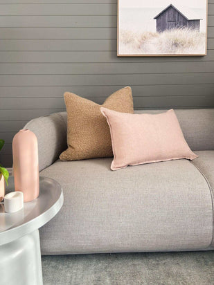 norsu Studio Bouclé Buff cushion with white leather piping on grey sofa