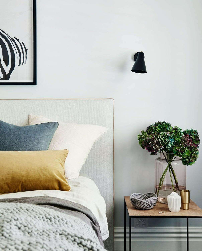 Caramel velvet norsu Studio Cushion with blush leather piping on a bed in a modern bedroom setting