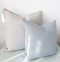 Two norsu Studio Cushions in Lexus Duck Egg color with soft fabric texture placed against a white wall