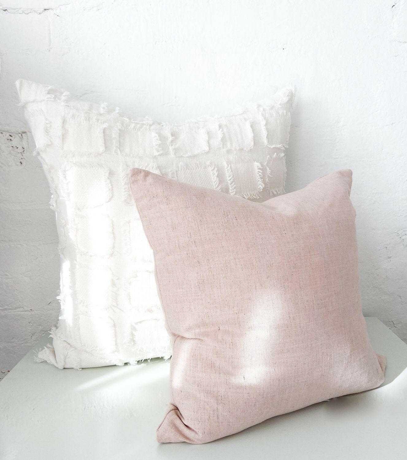 Handmade norsu cushion in Lexus Rosewater pink with soft fabric and feather down filling on a white textured cushion background