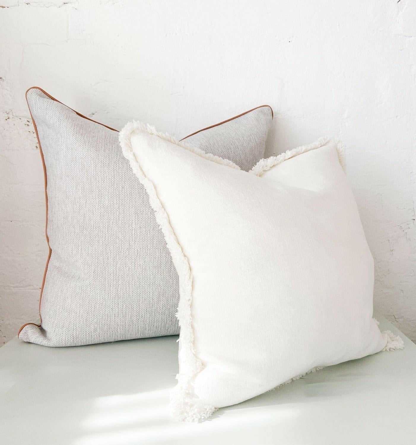 norsu Studio Cushion set featuring Lindeman Snow with blush piping, handmade with Warwick fabrics and feather down filling, perfect for home decor.