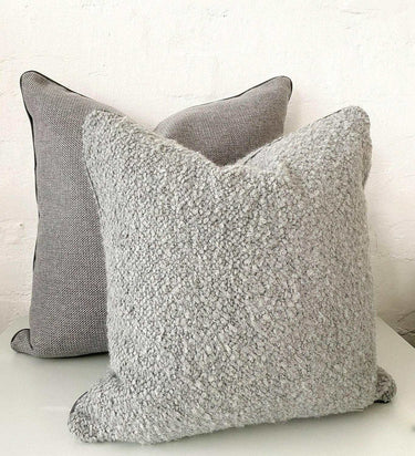 Two norsu cushions in Lindeman Steel fabric, one textured and one smooth, displayed against a white wall