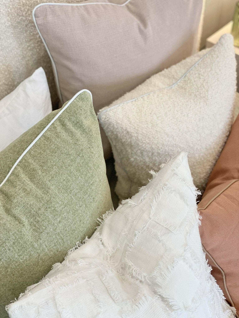 norsuHOME Cushion Parissi Pistachio green fabric cushion with white piping, displayed with textured white and neutral cushions on sofa
