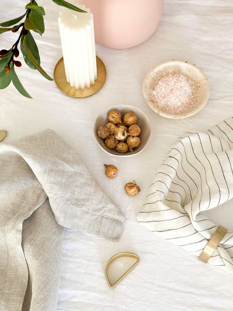 Set of four Rendr 100 Linen Napkins in natural color displayed with rustic table decor