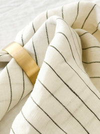 Set of four Rendr 100% linen napkins in striped olive pattern with brass napkin ring