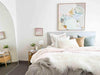 Modern bedroom with pastel-colored norsu studio washable cushions on bed and abstract wall art
