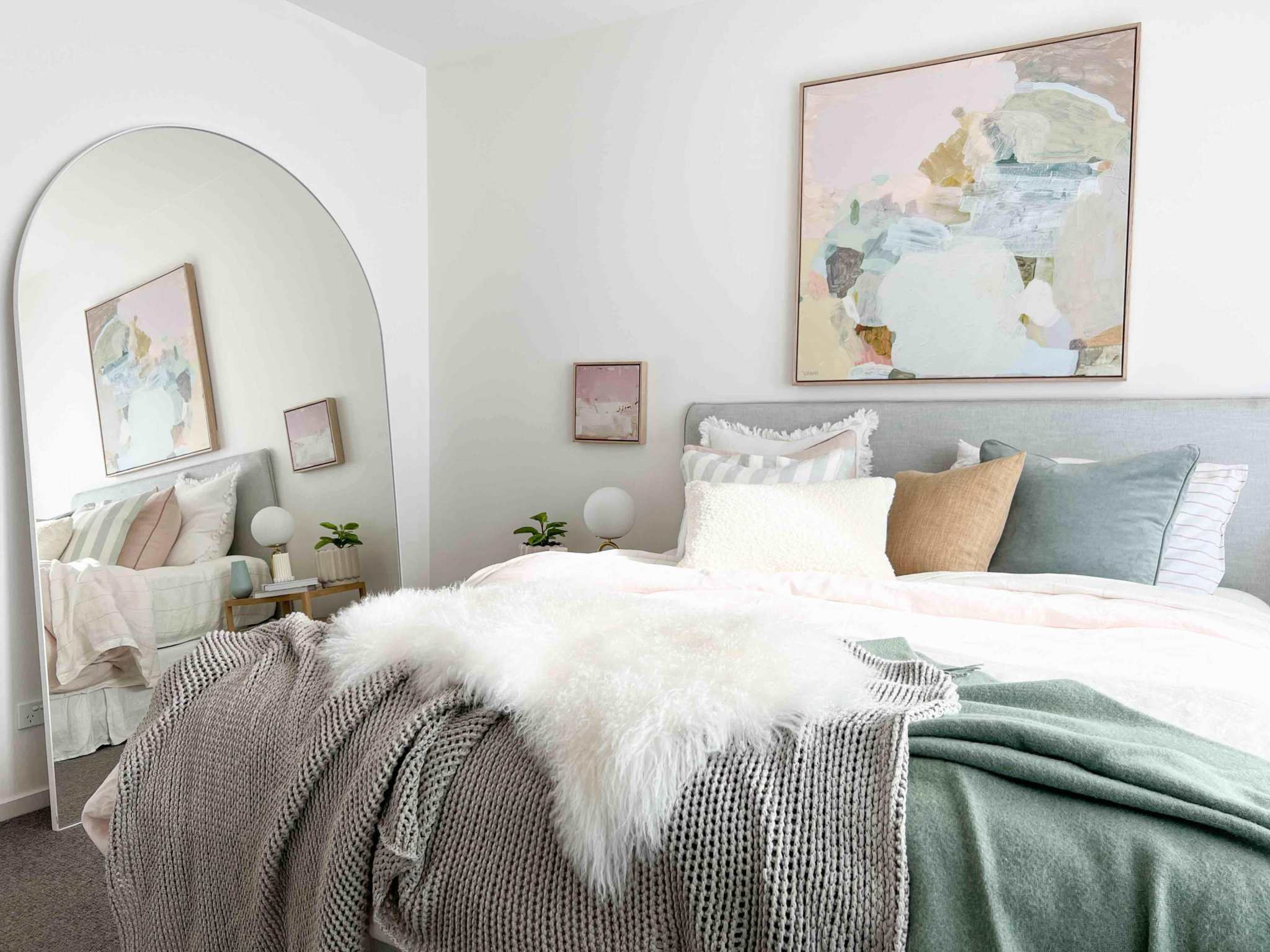 Middle of Nowhere Bjorn Arch oversized floor mirror in a modern bedroom setting with abstract wall art and cozy bedding.