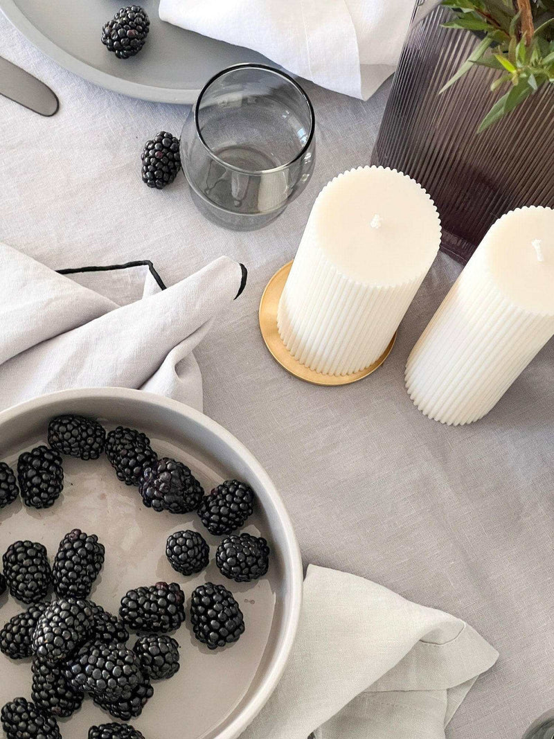 Rendr Amara Stitch 100% linen tablecloth in cool grey with contrasting embroidered edging, styled with candles and blackberries