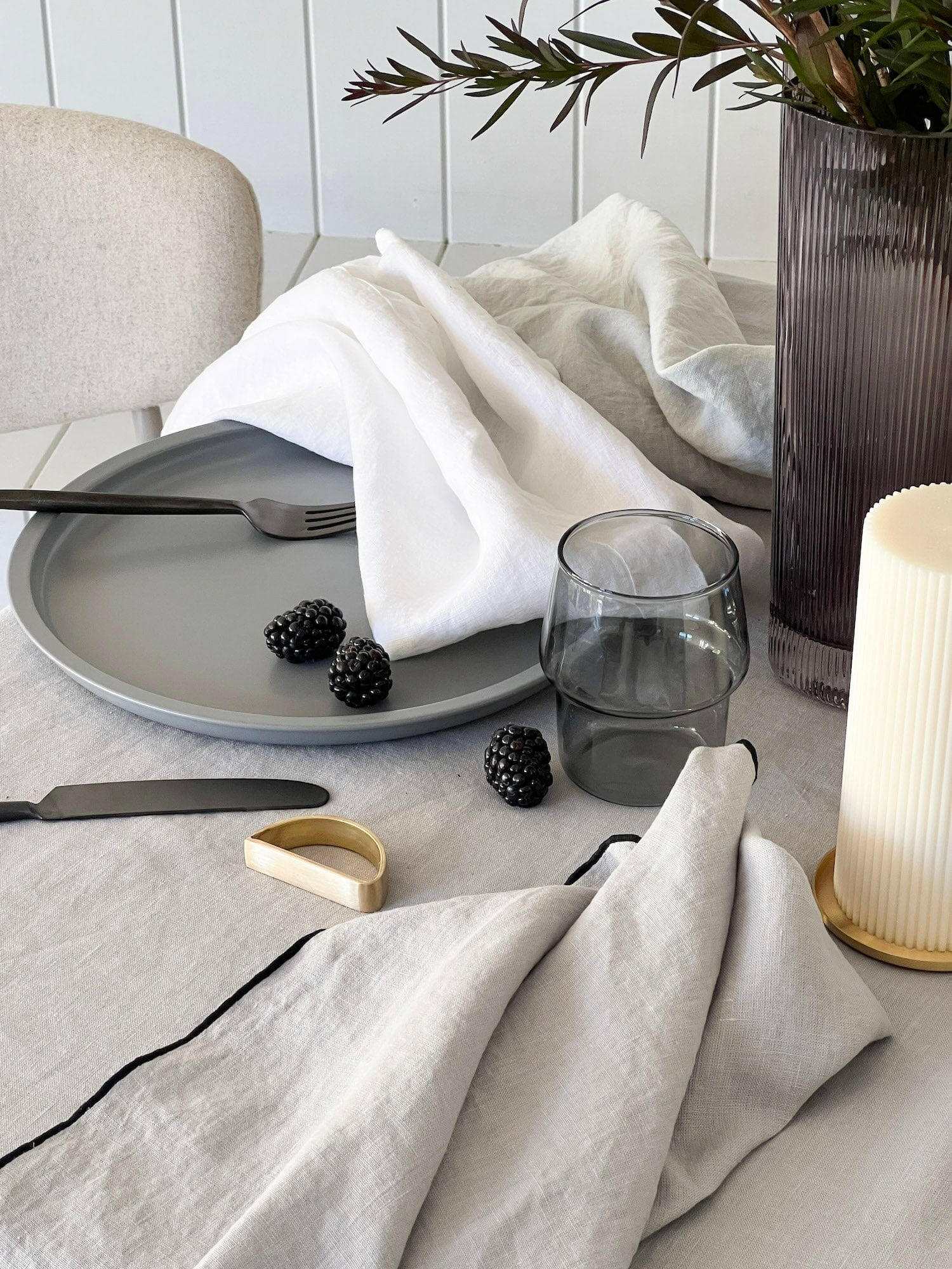 Set of four Rendr 100% linen white napkins on a dining table with glass, blackberries, and modern tableware