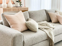 norsuHOME sofa beige fabric with soft cushions and a cozy throw in a stylish living room setting