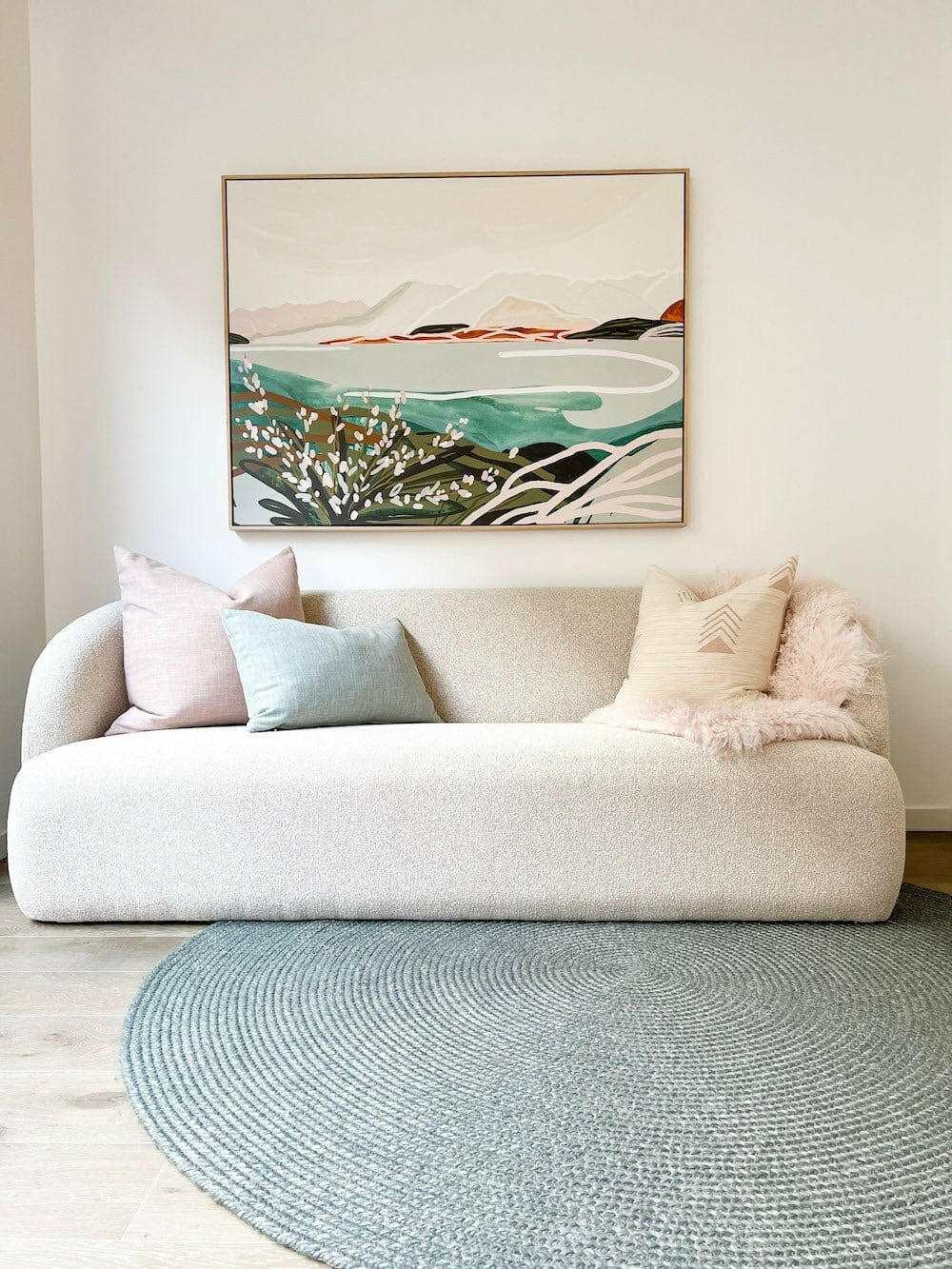 norsu Studio Washable Cushion in Duck Egg on beige sofa with modern abstract wall art and round blue rug