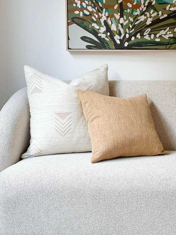 Norsu Studio Washable Cushion in honeycomb pattern and beige on a white sofa with a botanical painting in the background