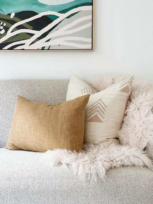 Norsu Studio Washable Cushion in honeycomb pattern on sofa with textured throw blanket and abstract wall art background