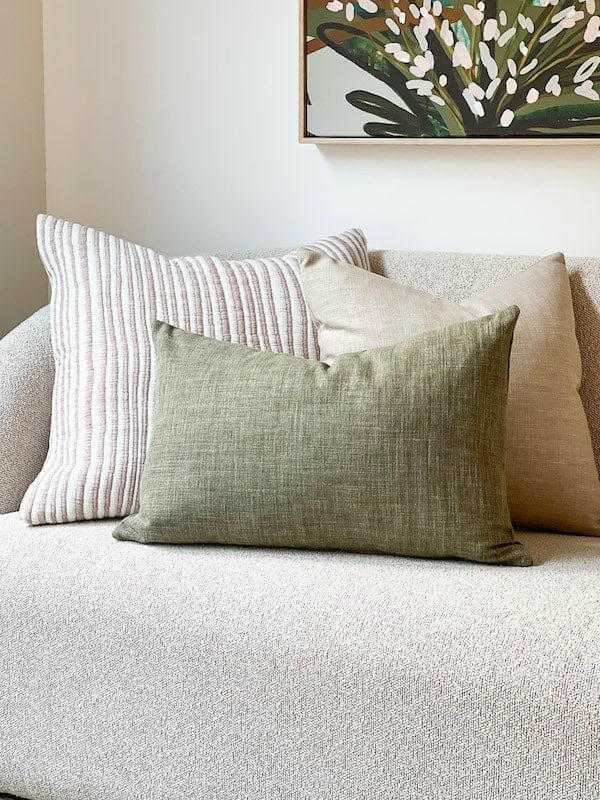 norsu Studio Washable Cushion in olive on sofa with textured beige and striped cushions
