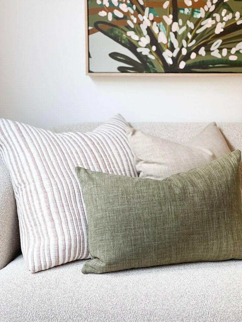 norsu Studio Washable Cushion in olive on sofa with decorative pillows and wall art