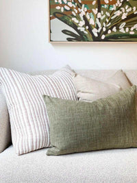 norsu Studio Washable Cushion in olive on sofa with decorative pillows and wall art