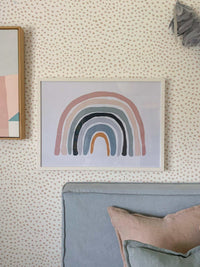 Over The Rainbow blush pastel rainbow art print framed on dotted wallpaper above grey sofa with cushions