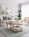 Pampas Zephyr framed print above beige sofa in modern living room with wooden coffee tables and natural light