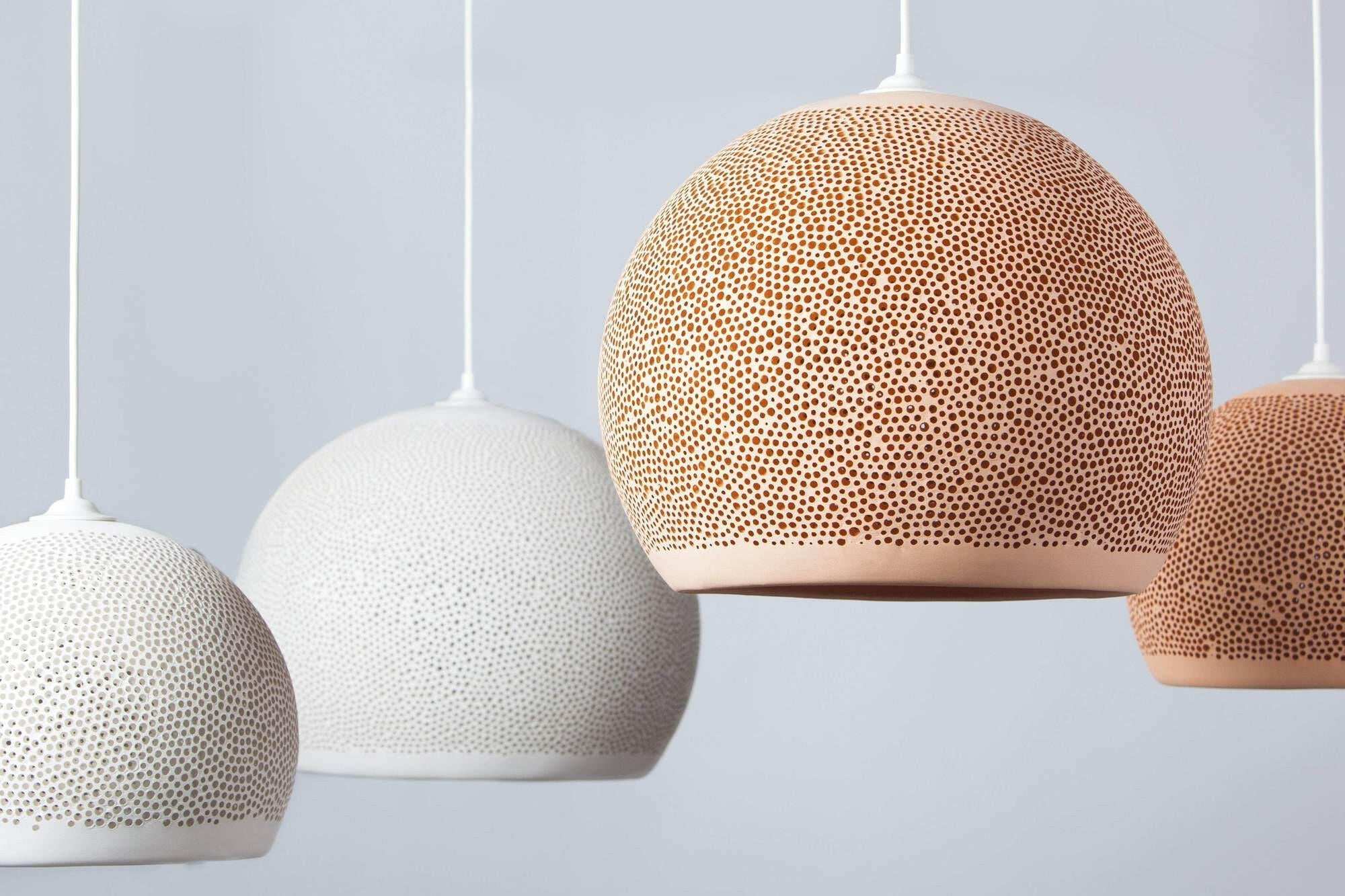 POTT Lighting SpongeUp Pendant lamps in white and terracotta with spongy textured surface hanging in a row