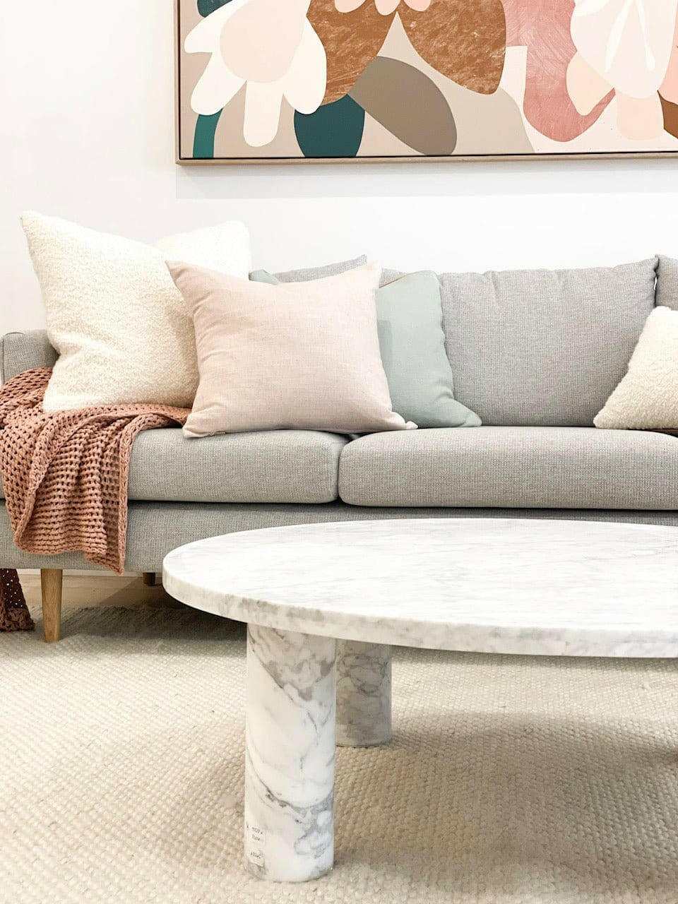 Modern living room with styled marble coffee table and cozy sofa cushions