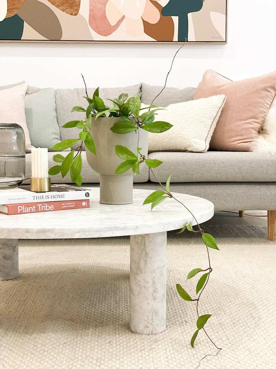 Modern coffee table styled with a green potted plant, books, and cozy living room decor for styling your coffee table.