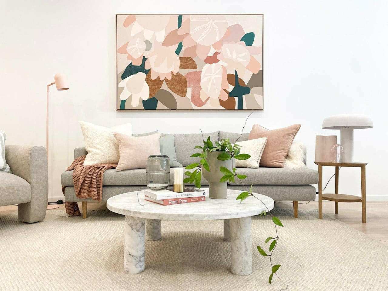 Modern living room featuring a styled round marble coffee table with decor and a comfortable sofa in neutral tones.