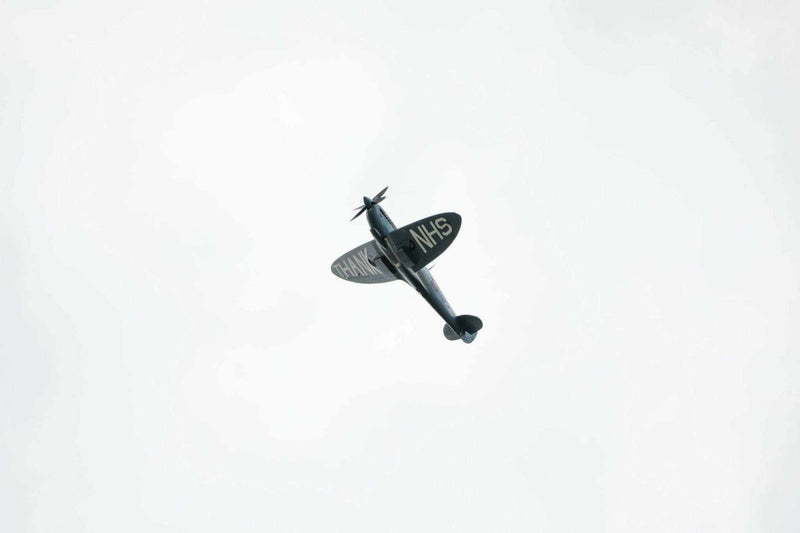 Vintage airplane flying with "THANK NHS" message on wings against clear sky, THANK U Print wall art.