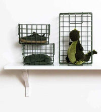 Set of three olive baskets in different sizes for locker storage, including one large and two small wire baskets on a white shelf