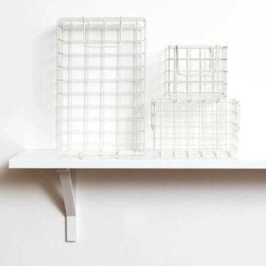 Set of chalk baskets in various sizes designed for locker storage, featuring a warm creamy white tone and wire grid design.