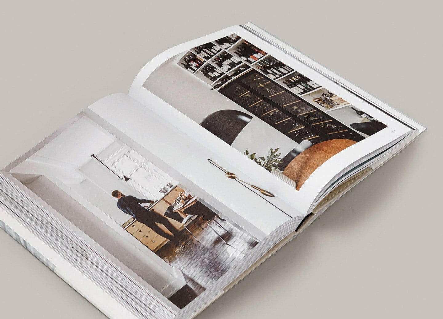 Open copy of The Kinfolk Home book displaying interior design photographs and lifestyle scenes