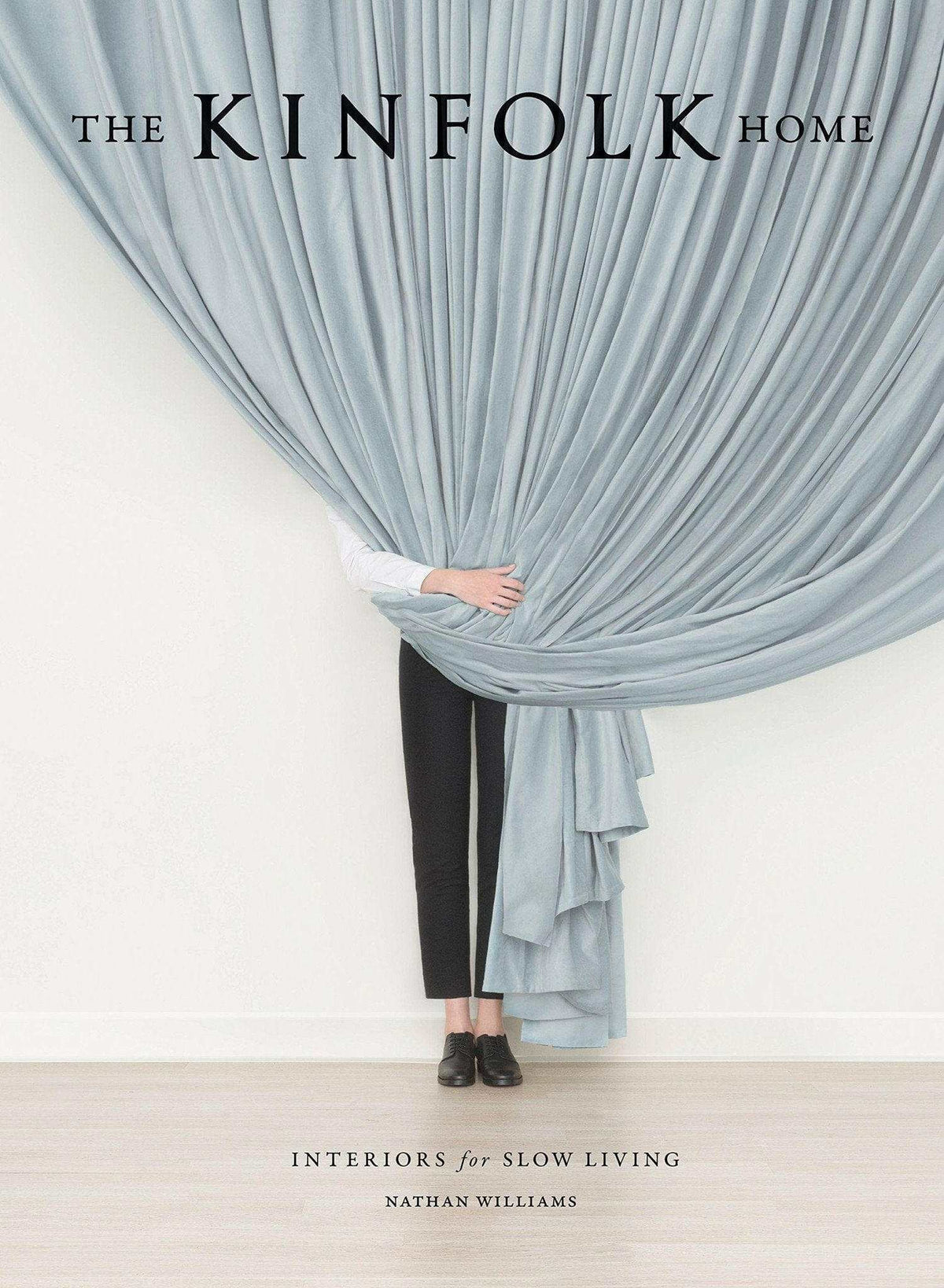 Cover of The Kinfolk Home book by Nathan Williams featuring person pulling back a large blue curtain.