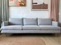 Custom Norsu Sofa 2.5 seater in Wells Driftwood fabric with minimalist design and wooden legs in a modern living room setting